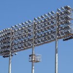 Floodlight towers against a clear blue sky