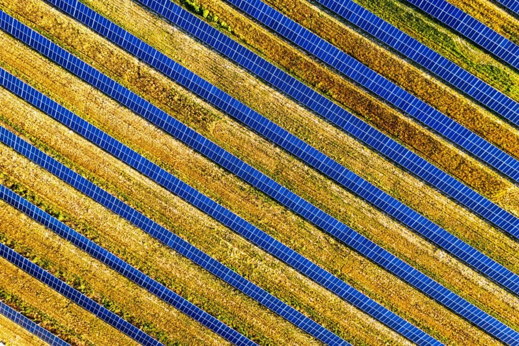 Aerial view of a solar farm with rows of panels