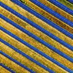 Aerial view of a solar farm with rows of panels